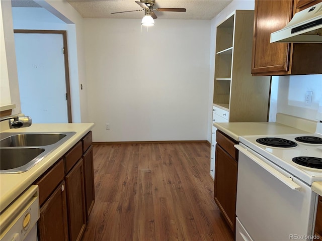 kitchen with a textured ceiling, sink, dark wood-type flooring, and white appliances