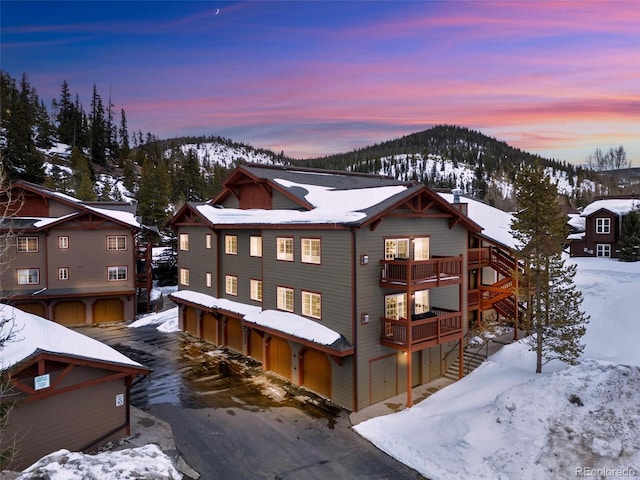 view of front of home featuring an attached garage, a balcony, and a mountain view