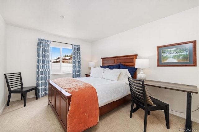 bedroom with baseboards and light colored carpet