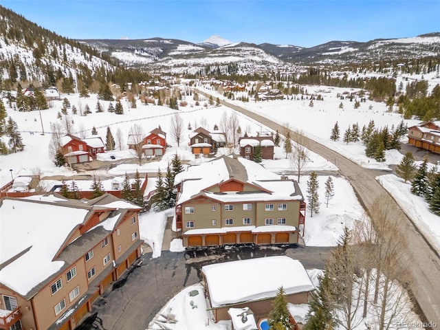 snowy aerial view featuring a residential view and a mountain view