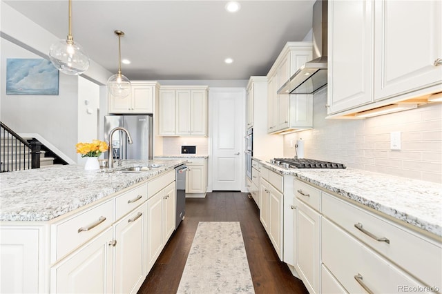 kitchen featuring a sink, tasteful backsplash, dark wood-style floors, stainless steel appliances, and wall chimney exhaust hood