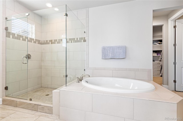 bathroom featuring a stall shower, recessed lighting, a bath, and a spacious closet