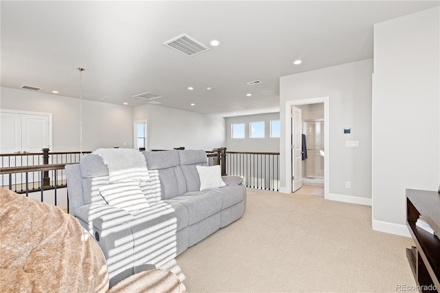 living area with recessed lighting, visible vents, light colored carpet, and baseboards