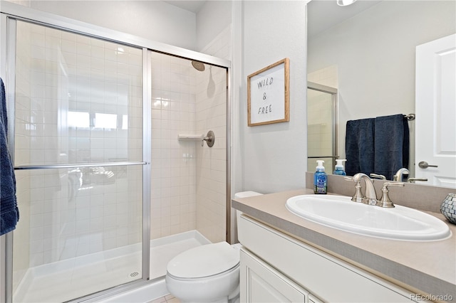 bathroom featuring vanity, toilet, and a shower stall