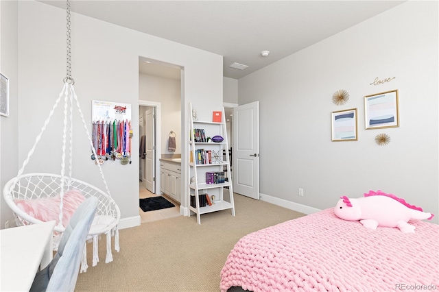 bedroom with ensuite bath, baseboards, and light carpet