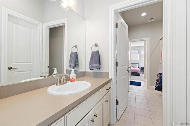 ensuite bathroom with tile patterned floors, visible vents, connected bathroom, and vanity