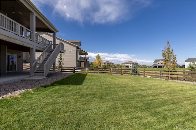 view of yard featuring a wooden deck, stairs, and fence