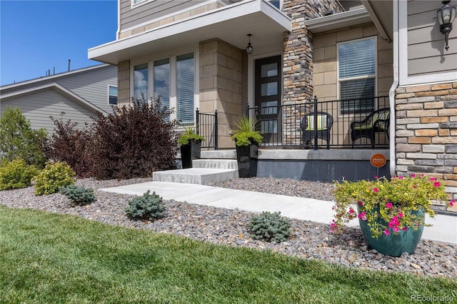 property entrance featuring a porch and stone siding