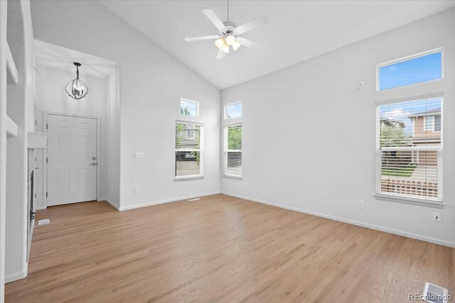 10685 Cherrybrook Cir, Highlands Ranch, CO 80126 - unfurnished living room with high vaulted ceiling, light wood finished floors, a chandelier, baseboards, and ceiling fan