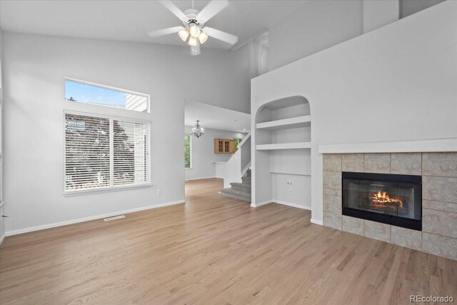 10685 Cherrybrook Cir, Highlands Ranch, CO 80126 - unfurnished living room with a high ceiling, built in features, baseboards, stairway, and wood finished floors