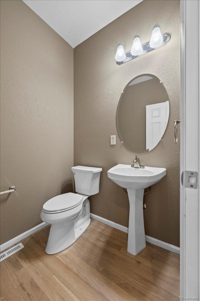 10685 Cherrybrook Cir, Highlands Ranch, CO 80126 - bathroom featuring wood finished floors, toilet, and baseboards