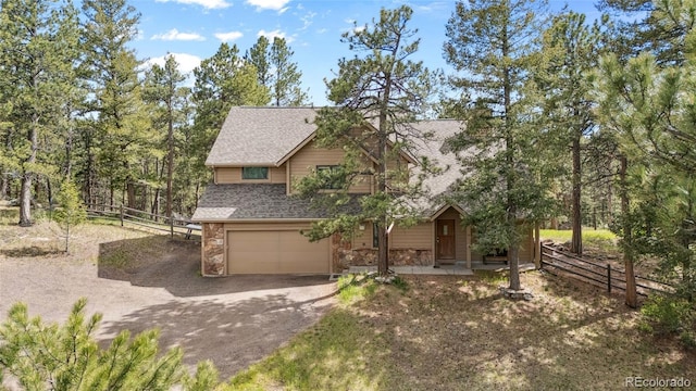 4992 White House Trl, Evergreen, CO 80439 - view of front facade with stone siding, roof with shingles, dirt driveway, and a garage