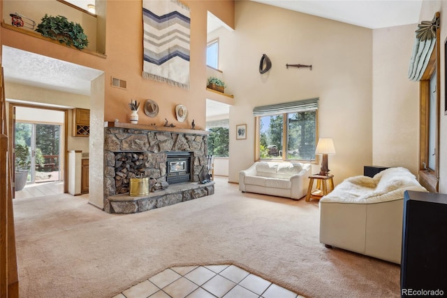 4992 White House Trl, Evergreen, CO 80439 - living area featuring carpet flooring, a towering ceiling, tile patterned floors, and a stone fireplace