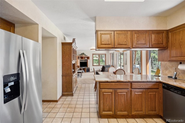 4992 White House Trl, Evergreen, CO 80439 - kitchen featuring appliances with stainless steel finishes, open floor plan, brown cabinets, a peninsula, and healthy amount of natural light