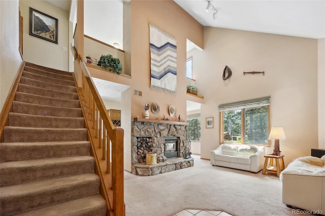 4992 White House Trl, Evergreen, CO 80439 - living room featuring carpet, stairs, rail lighting, a towering ceiling, and a fireplace
