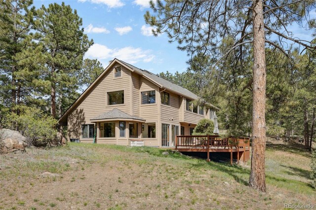 4992 White House Trl, Evergreen, CO 80439 - rear view of house with a wooden deck and a lawn