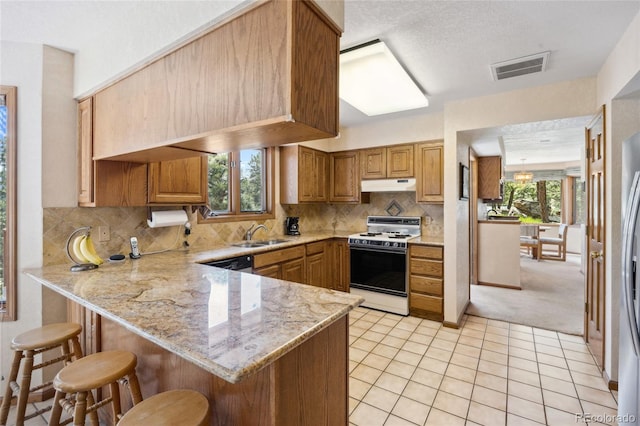 4992 White House Trl, Evergreen, CO 80439 - kitchen featuring white range oven, a peninsula, under cabinet range hood, a breakfast bar, and light stone countertops