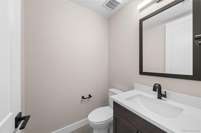 bathroom featuring toilet, baseboards, visible vents, and vanity