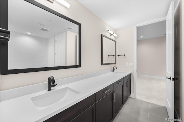 full bath with visible vents, a sink, baseboards, and double vanity