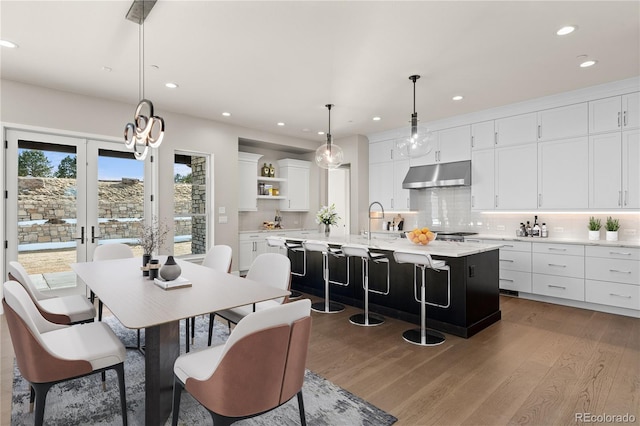 dining space with french doors, wood finished floors, and recessed lighting