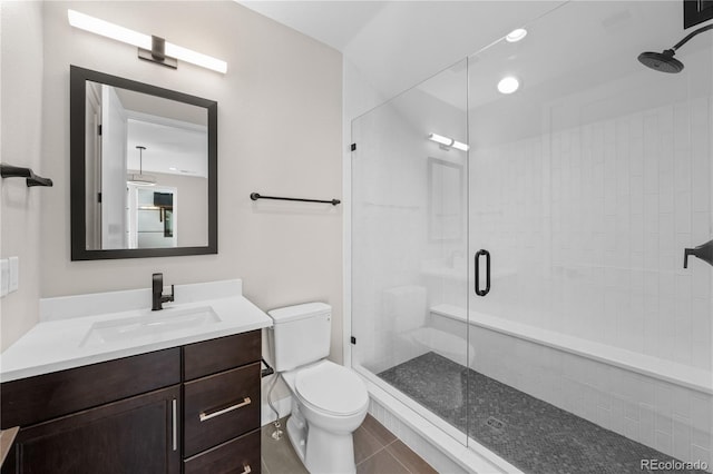 bathroom featuring toilet, a shower stall, tile patterned flooring, and vanity