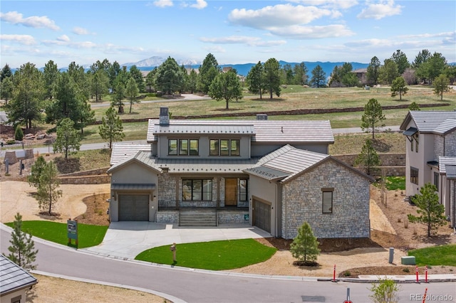 8014 Trinity Peak Ln, Castle Rock, CO 80108 - view of front of property with concrete driveway, a mountain view, stone siding, stucco siding, and a garage