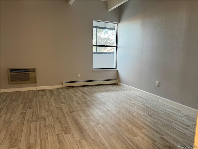 spare room with a baseboard radiator, light wood-style flooring, baseboards, and a wall mounted AC