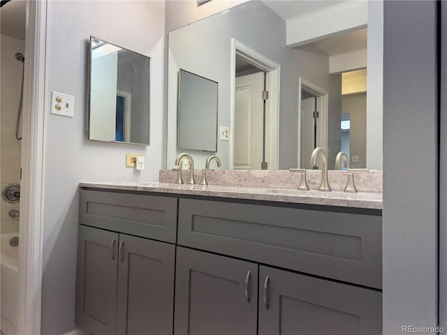 bathroom with  shower combination, a sink, and double vanity