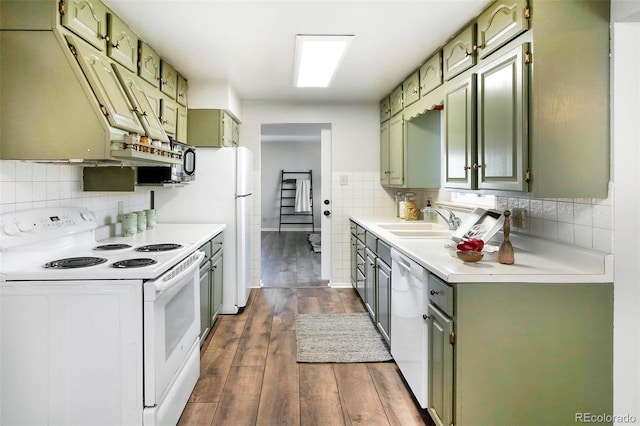 kitchen featuring sink, tasteful backsplash, green cabinetry, dark hardwood / wood-style floors, and white appliances