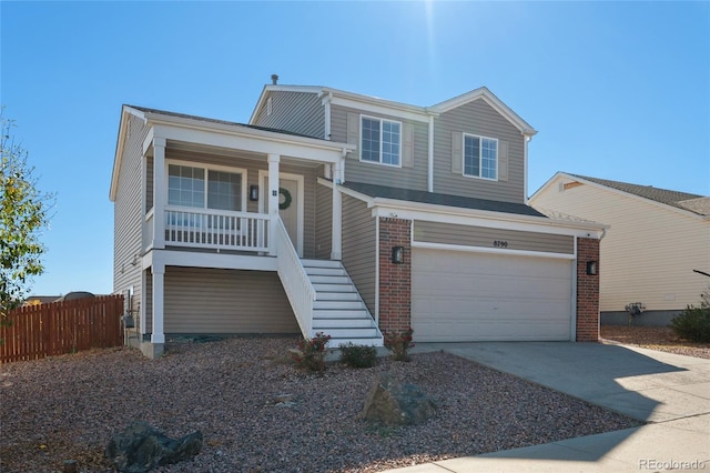 view of front of house featuring fence, stairway, covered porch, concrete driveway, and brick siding