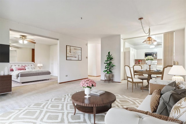 carpeted living room with ceiling fan