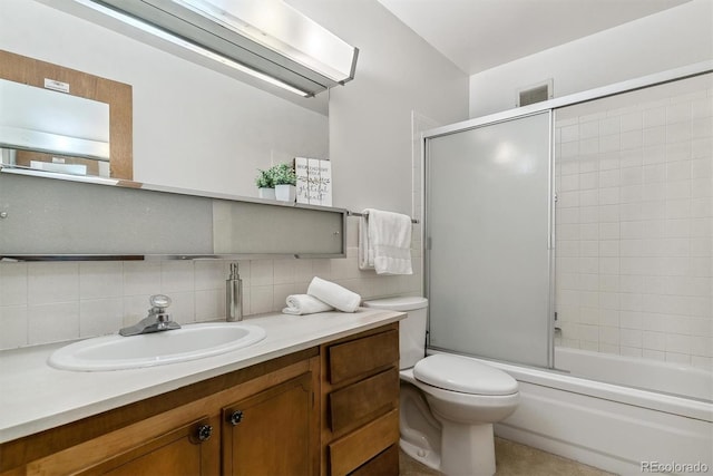 full bathroom with enclosed tub / shower combo, vanity, toilet, and tasteful backsplash