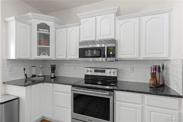 kitchen featuring backsplash, white cabinetry, stainless steel appliances, and vaulted ceiling