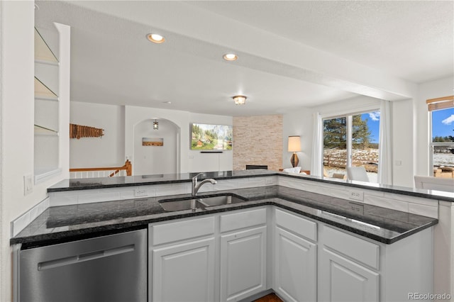 kitchen with white cabinets, dark stone countertops, dishwasher, and sink