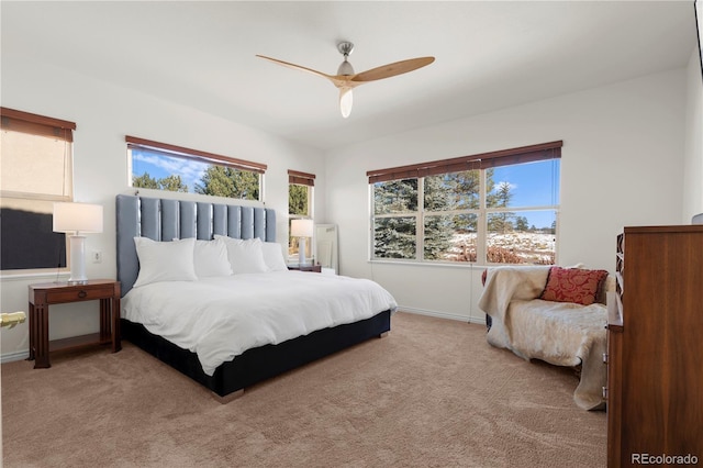 bedroom with multiple windows, ceiling fan, and light colored carpet