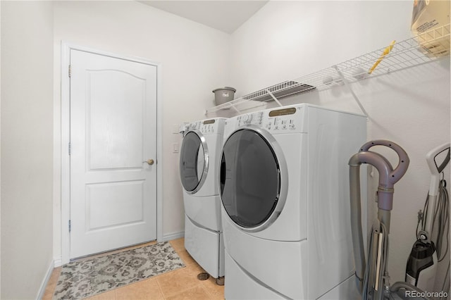 laundry room with independent washer and dryer and light tile patterned flooring