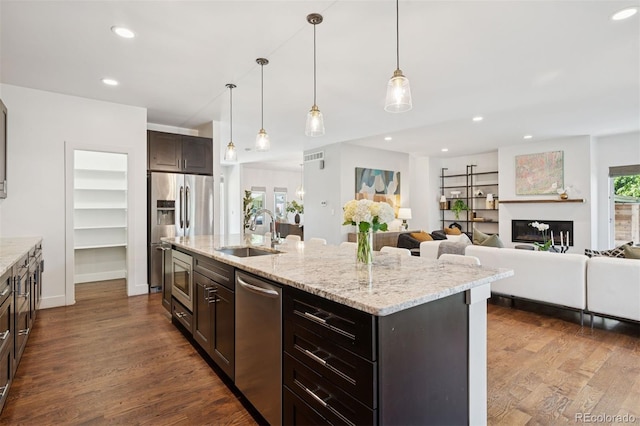 2377 S Humboldt St, Denver, CO 80210 - kitchen with appliances with stainless steel finishes, dark wood-style flooring, recessed lighting, dark brown cabinets, and an island with sink