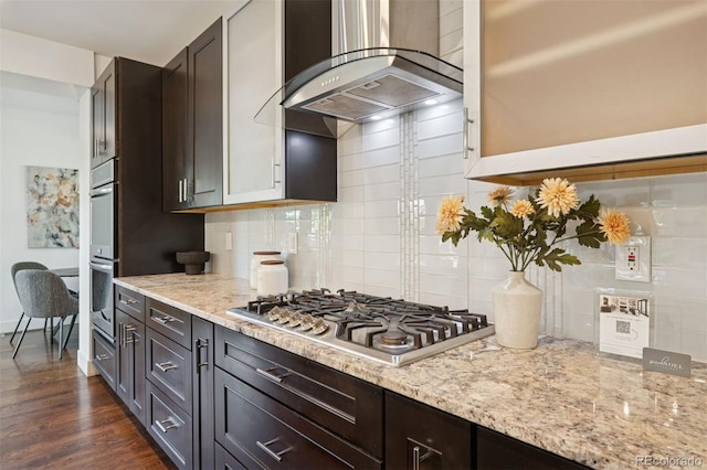 2377 S Humboldt St, Denver, CO 80210 - kitchen with wall chimney range hood, stainless steel appliances, decorative backsplash, light stone countertops, and dark wood-style flooring