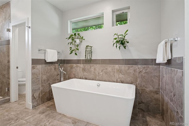 2377 S Humboldt St, Denver, CO 80210 - full bath with tile walls, a soaking tub, marble finish floors, wainscoting, and a tile shower