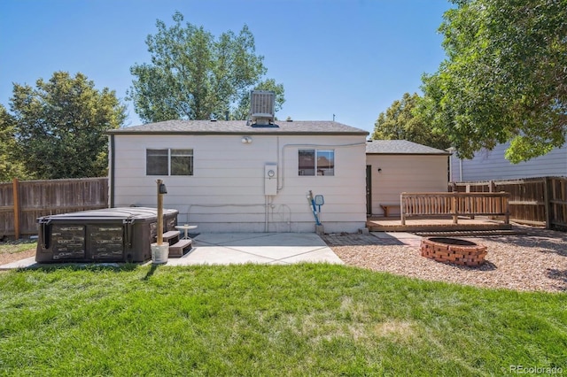 20714 E Buchanan Dr, Aurora, CO 80011 - rear view of property featuring a hot tub, an outdoor fire pit, a fenced backyard, and a patio