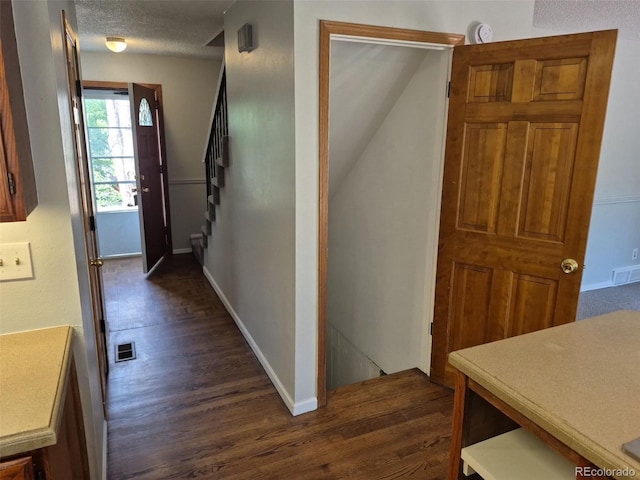 16835 E Harvard Pl, Aurora, CO 80013 - corridor featuring dark wood-type flooring, baseboards, stairs, and a textured ceiling