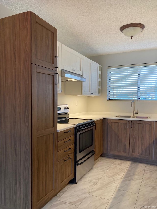 kitchen featuring a textured ceiling, sink, and stainless steel range with electric stovetop