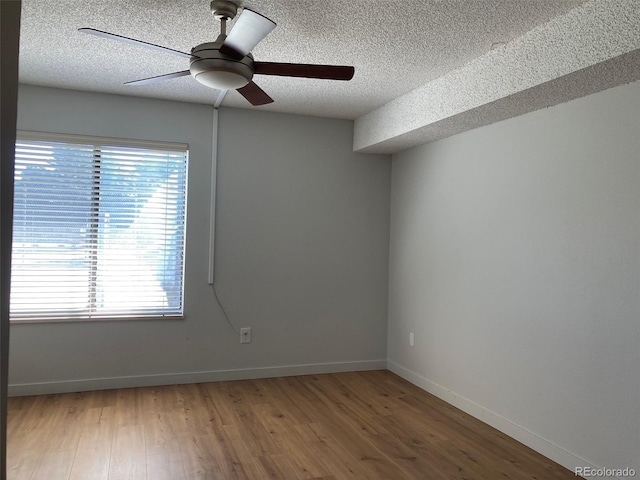 empty room with hardwood / wood-style floors, ceiling fan, and a textured ceiling