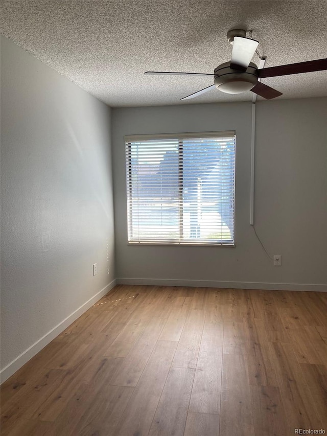 spare room with hardwood / wood-style flooring, ceiling fan, and a textured ceiling