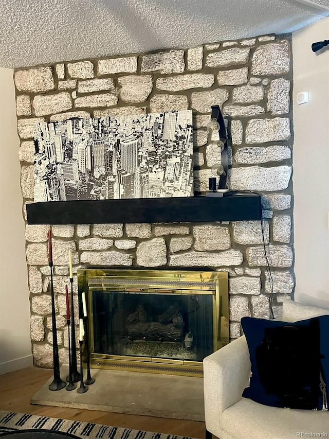 room details with a fireplace, hardwood / wood-style floors, and a textured ceiling