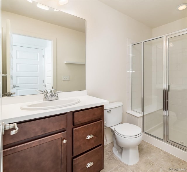 bathroom with a shower stall, toilet, vanity, and tile patterned flooring