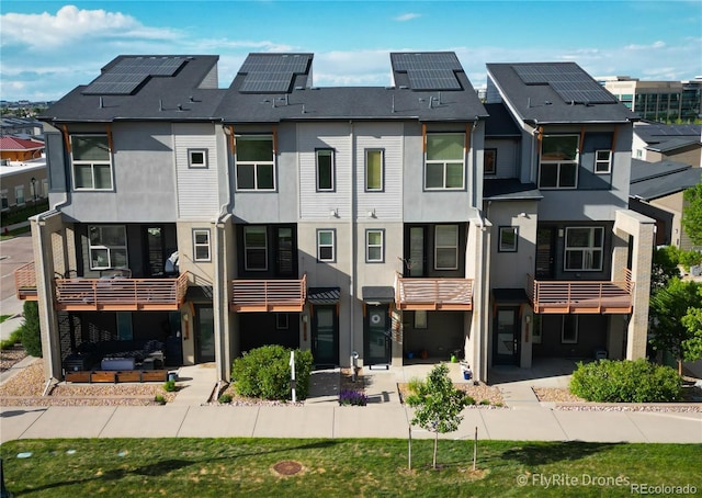 10154 Belvedere Loop, Lone Tree, CO 80124 - back of property with stucco siding, a residential view, roof mounted solar panels, and a balcony