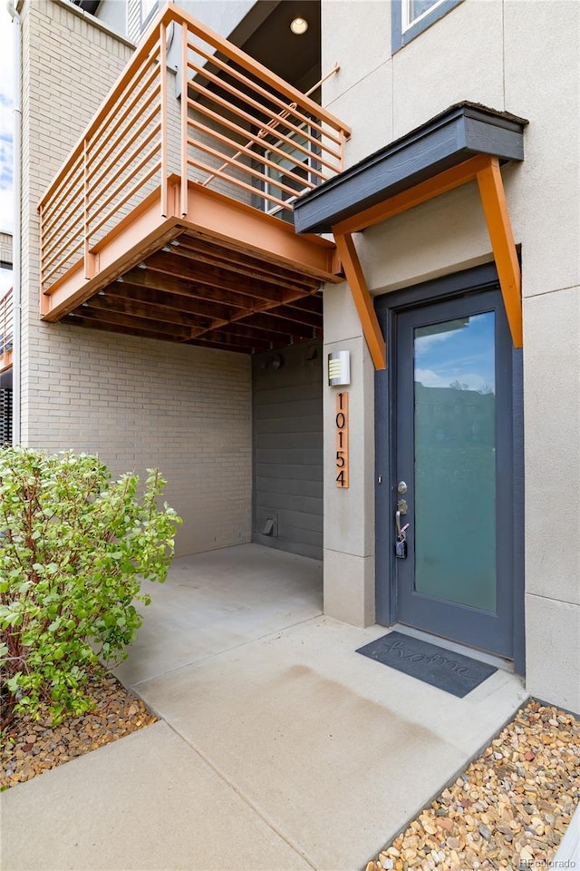 10154 Belvedere Loop, Lone Tree, CO 80124 - doorway to property with a balcony, brick siding, and stucco siding