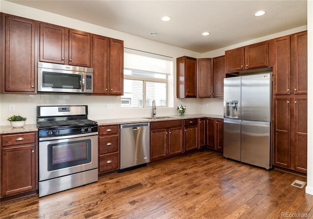 10154 Belvedere Loop, Lone Tree, CO 80124 - kitchen with stainless steel appliances, a sink, dark wood finished floors, recessed lighting, and backsplash