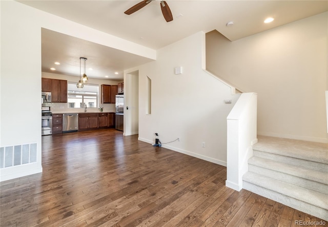 10154 Belvedere Loop, Lone Tree, CO 80124 - unfurnished living room with dark wood-type flooring, ceiling fan, stairs, baseboards, and recessed lighting